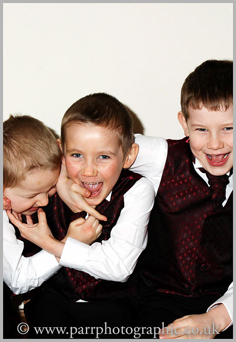 Three boys play on a church bench