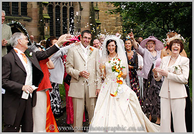 Wedding party throw confetti over the bride and groom