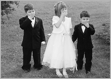 Three children cover their mouths