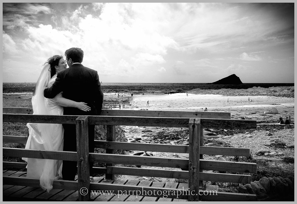 Bride and groom on a bridge on Wembury beach Devon